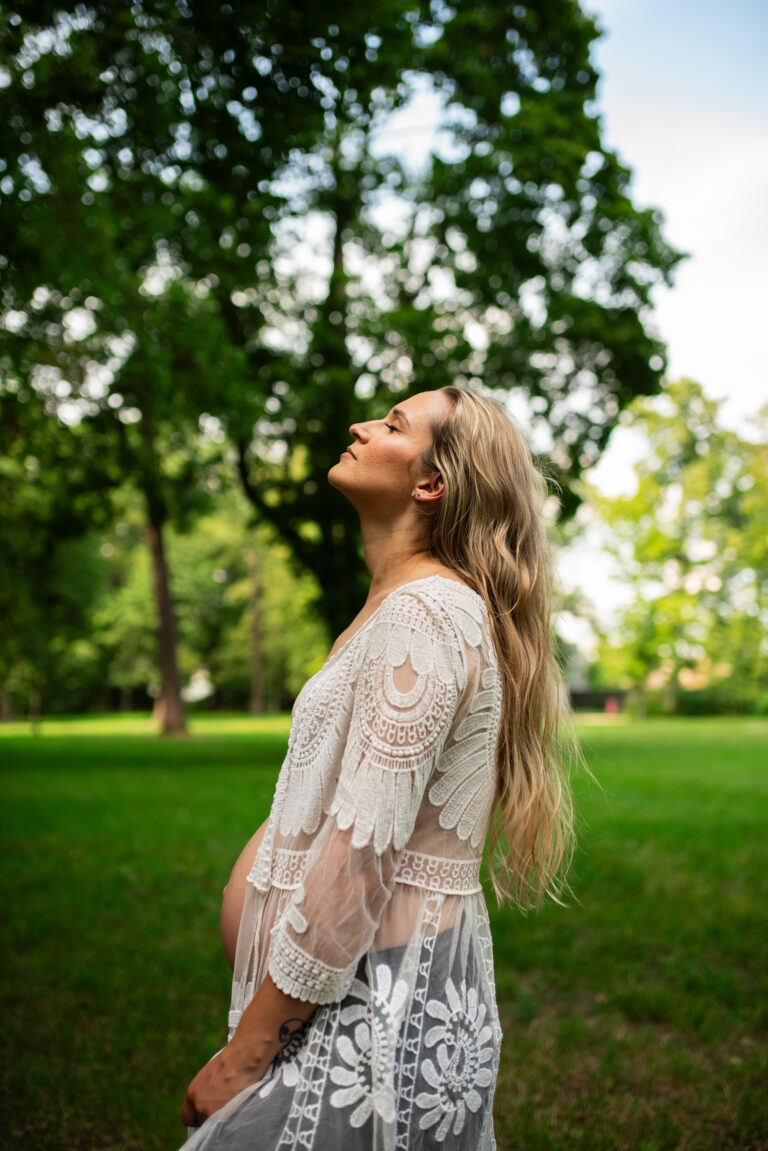 Przyszła mama na tle drzew - sesja ciążowa Warszawa