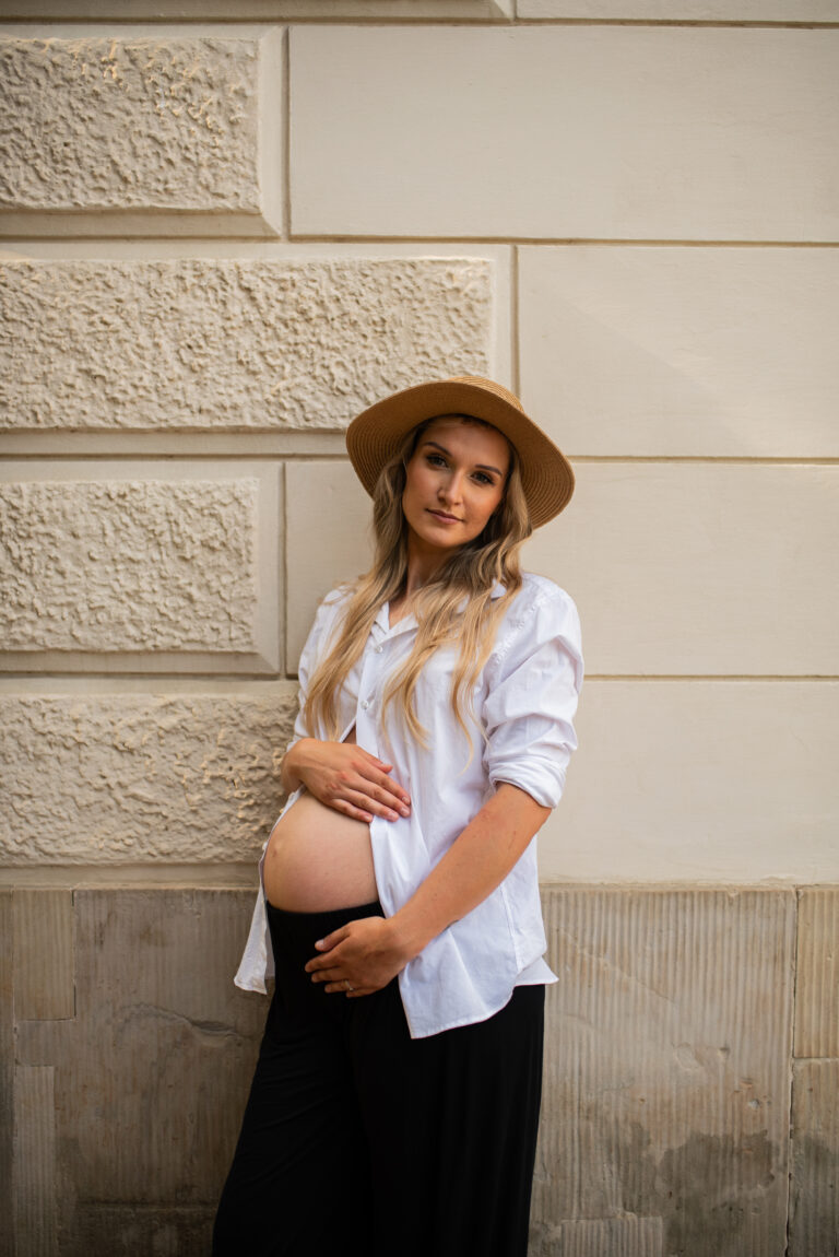 Kobieta w ciąży stojąca w parku z pałacem - Warszawa