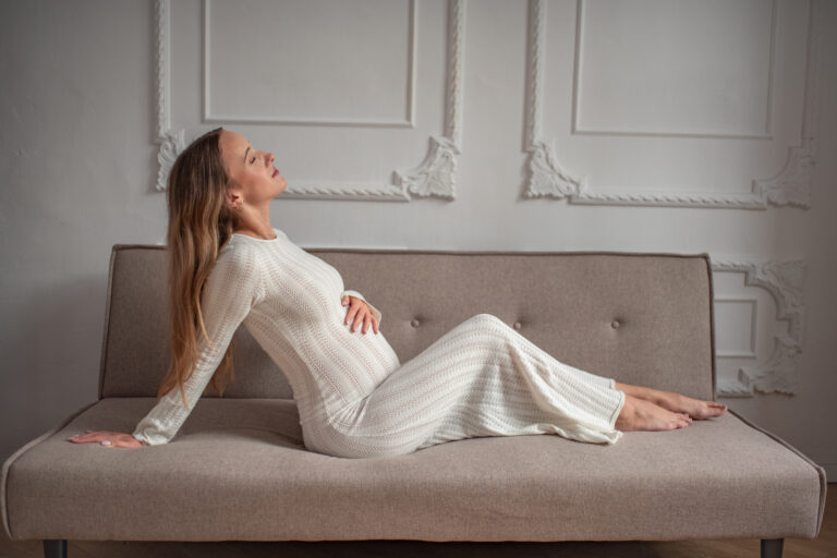 Kobieta w ciąży na kanapie - zdjęcia studyjne Warszawa