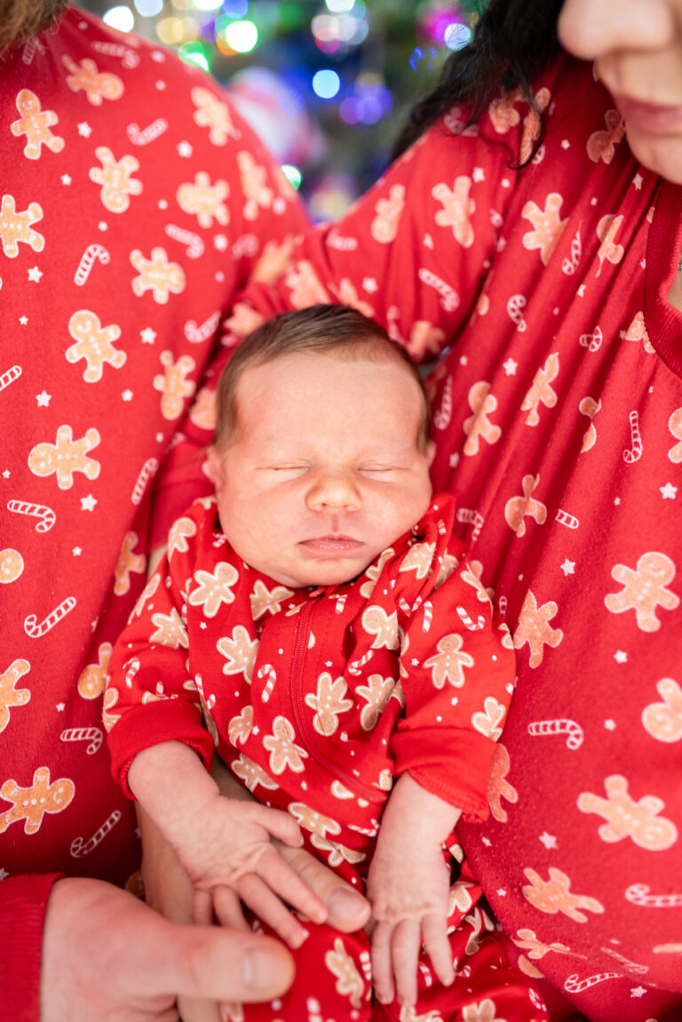 Sesja noworodkowa w domu w Warszawie – noworodek wtulony w ramiona rodziców