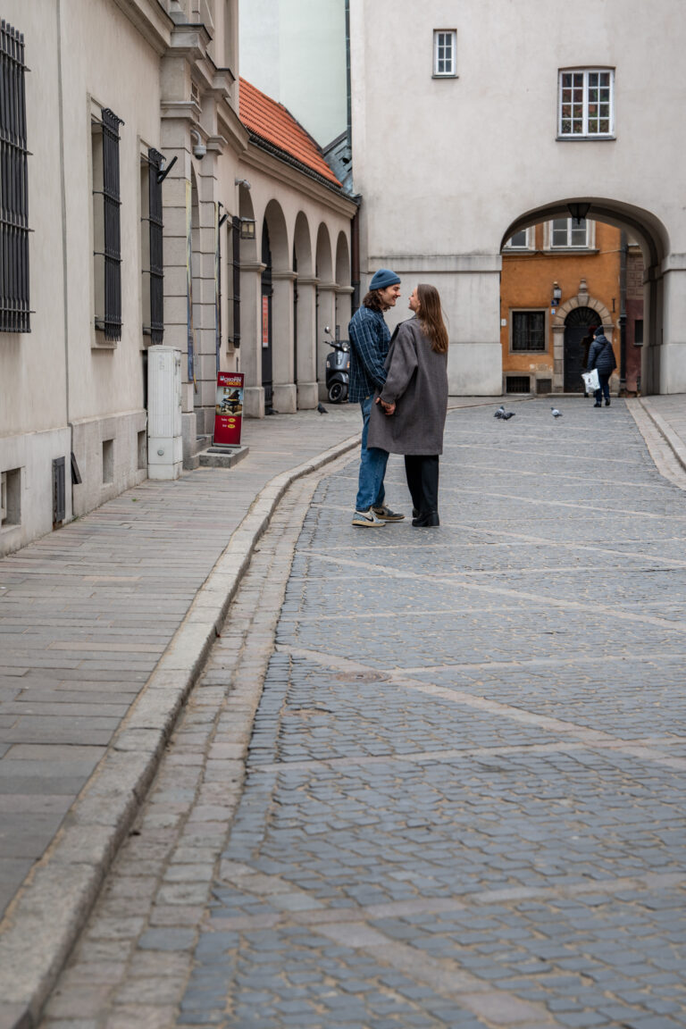 Para spacerująca po brukowanych ulicach Warszawy